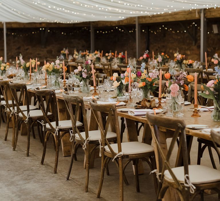 Marquee wedding reception decorated with colourful wedding flower arrangements on the tables 