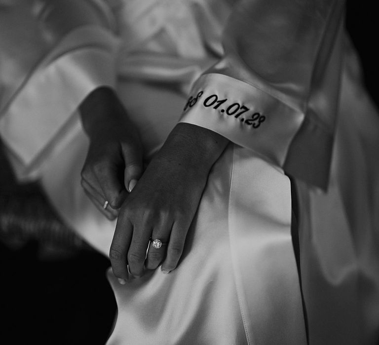 embroidered wedding date on the cuff of the brides satin getting ready robe 