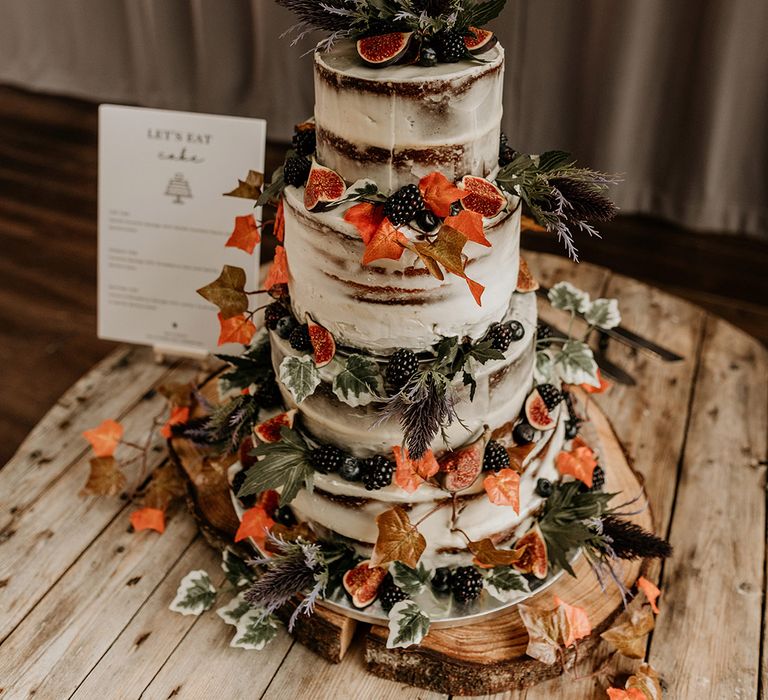 Semi naked autumnal wedding cake decorated with autumn leaves and more 