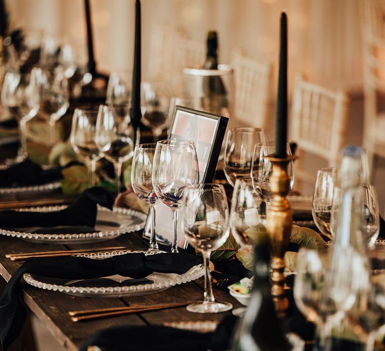 Black napkins, candles and more at wedding tablescape in marquee 