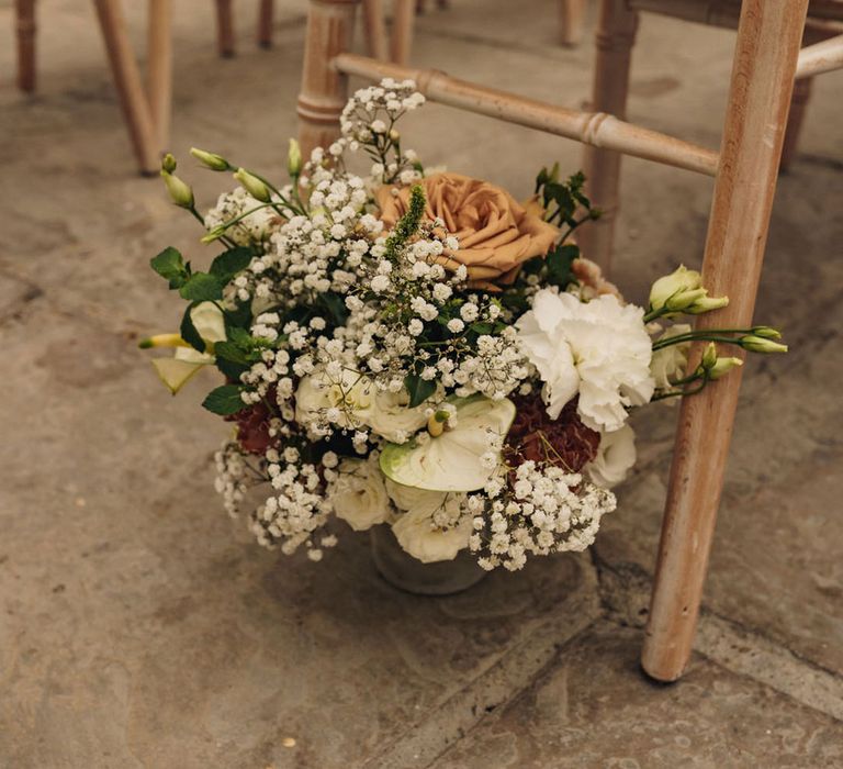 Toffee roses, white lilies, gypsophila and more in aisle flower arrangements 