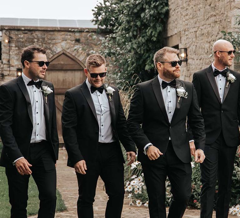 Groomsmen in tuxedoss at rustic luxe wedding