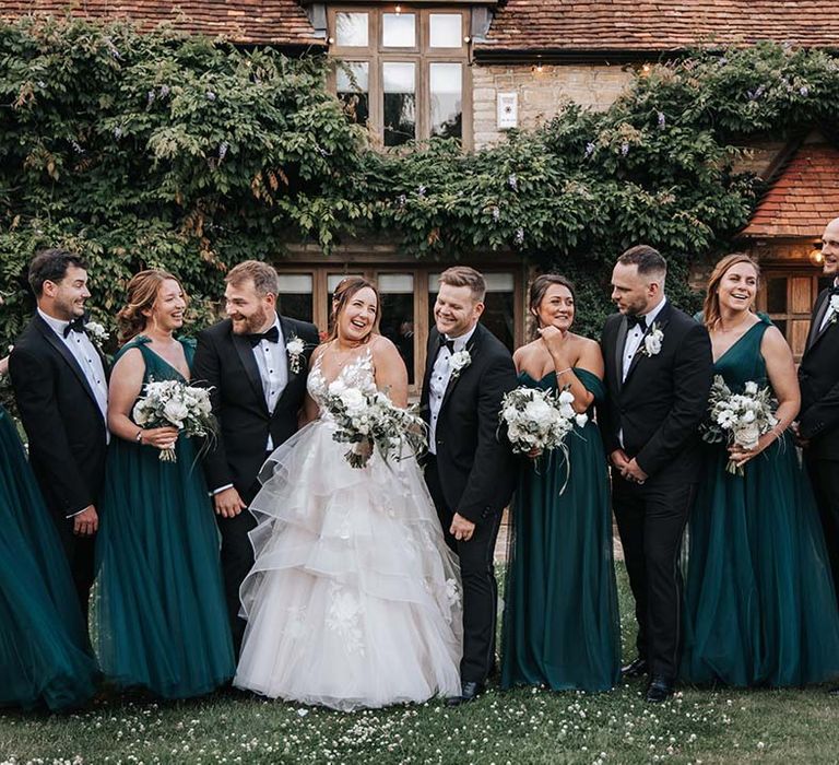 Wedding party photograph with green bridesmaid dresses and tuxedos