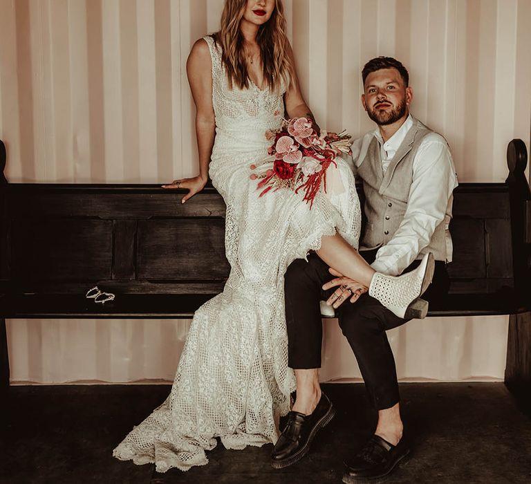 Groom in shirt and waistcoat with the bride at their industrial wedding venue with a rustic styling 