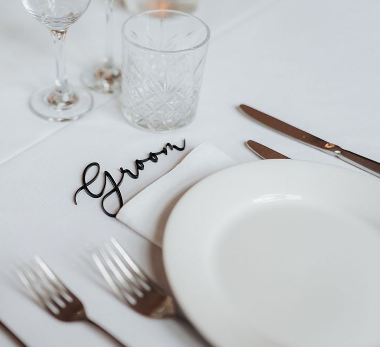 Minimalist wedding place name above the white plates 