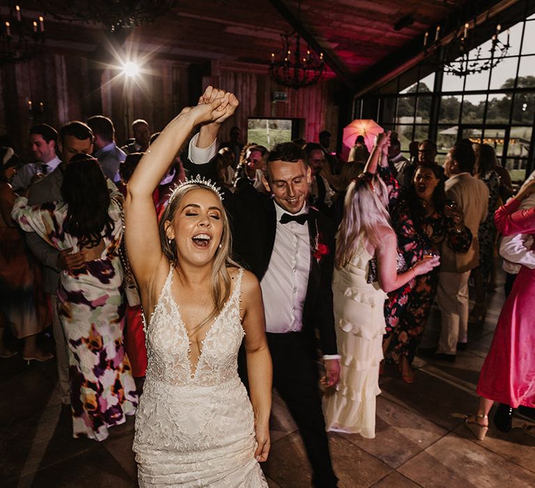 Wedding reception party with the bride and groom dancing with their guests 