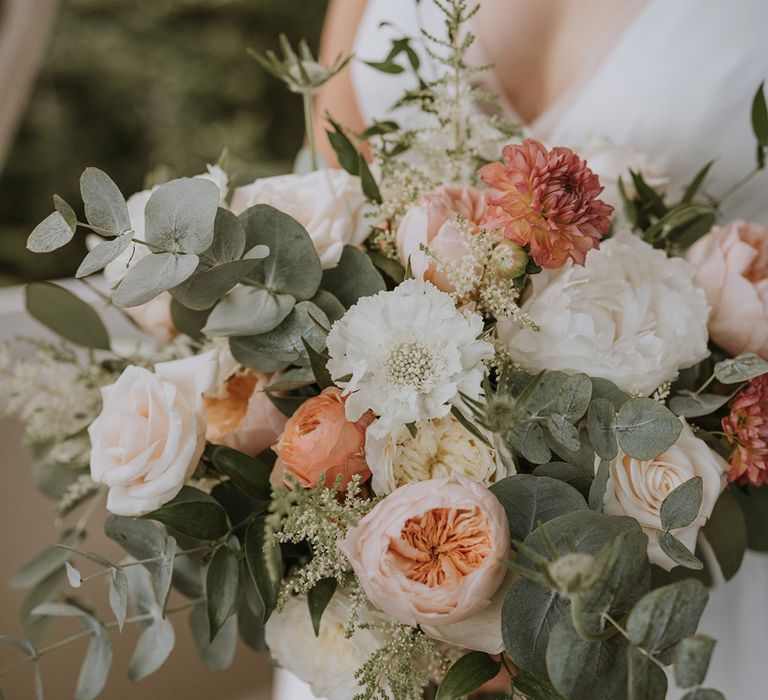 Peonies and roses in pastel pink and peach wedding bouquet for beach wedding