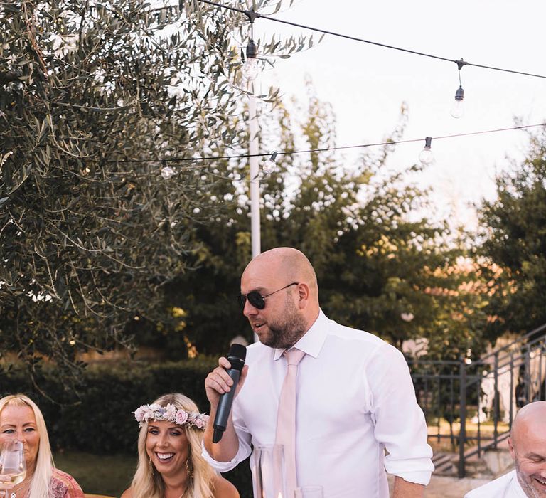 Groom reading out wedding speech at outdoor wedding 