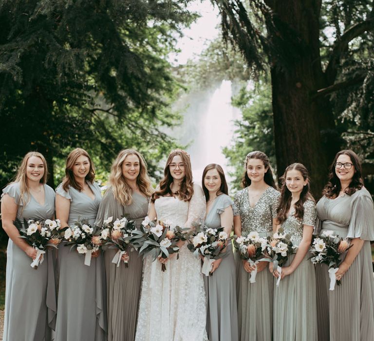 The bridal party wearing mismatched pale green bridesmaid dresses for botanical wedding 