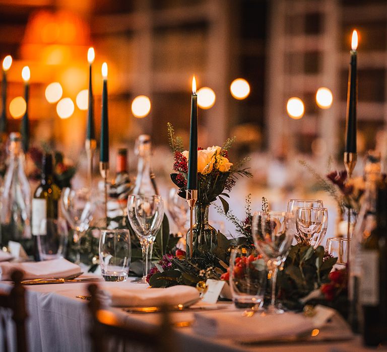 Magical wedding tablescape for festive Christmas wedding with red and green theme, candles and bell place name cards 