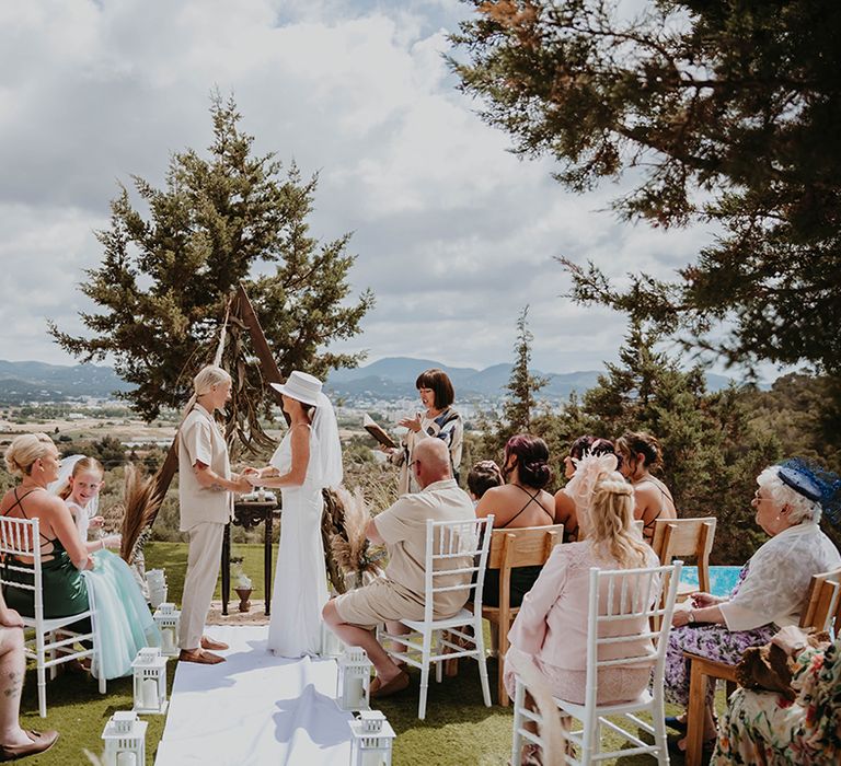 Outdoor rustic wedding ceremony in Ibiza with wooden altar decoration 