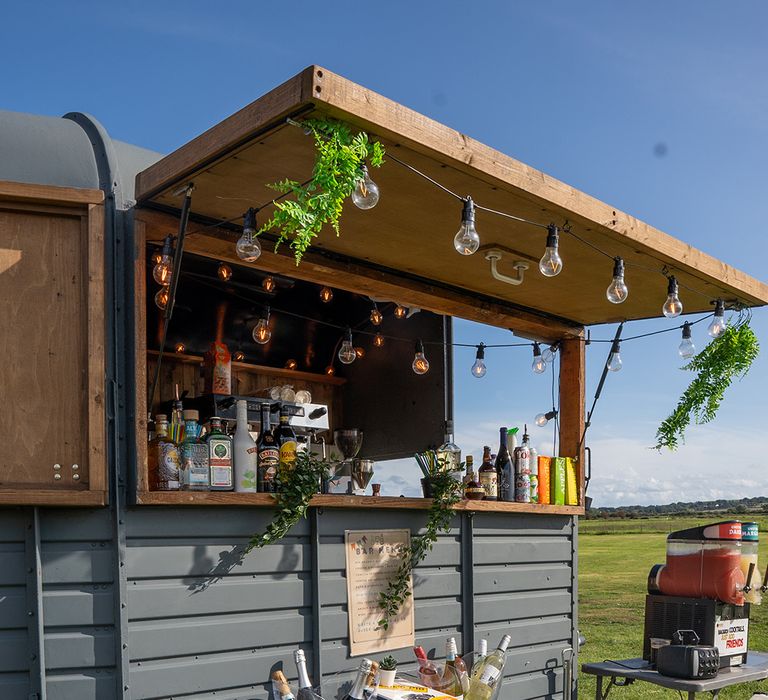 Mobile wedding bar serving drinks to guests for festival theme wedding 