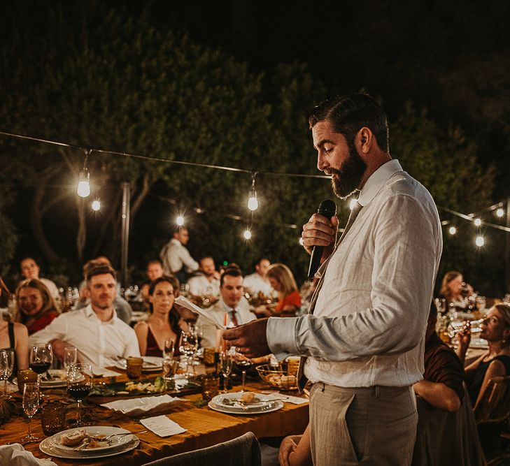 Groom delivering the speech at outdoor wedding 