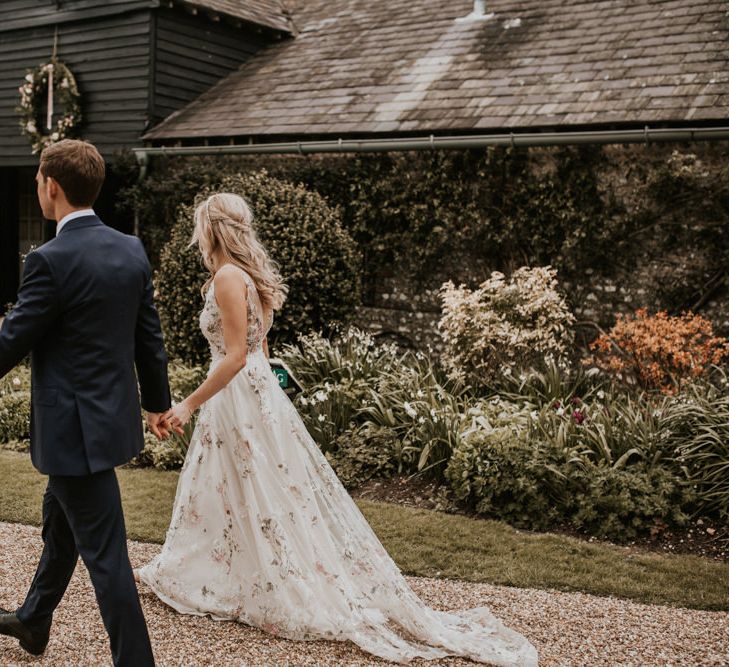 Bride and groom holding hands at their wedding venue Upwaltham Barns 