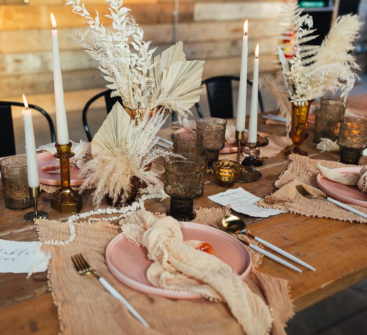 Place setting with pink charger plate, white cutlery and beige linen napkins 