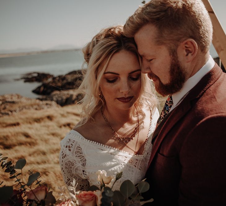 Bride and groom enjoy each other's presence in front of the sea at Anglesey Island with boho themes