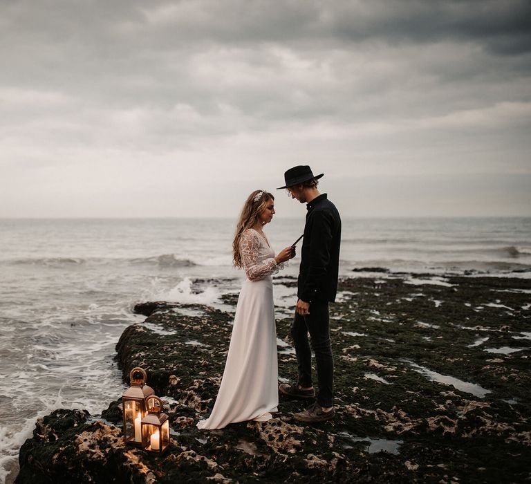 Bride and groom exchanging vows on the rocks at their coastal elopement 