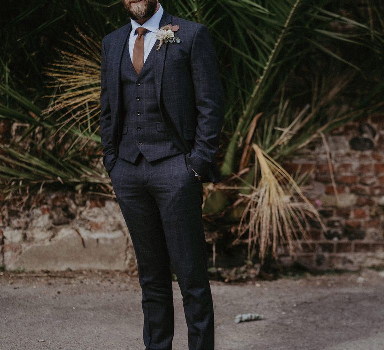 Groom in stylish navy wool three-piece suit