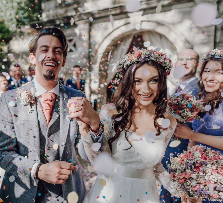 Bride and groom walk through confetti cannons