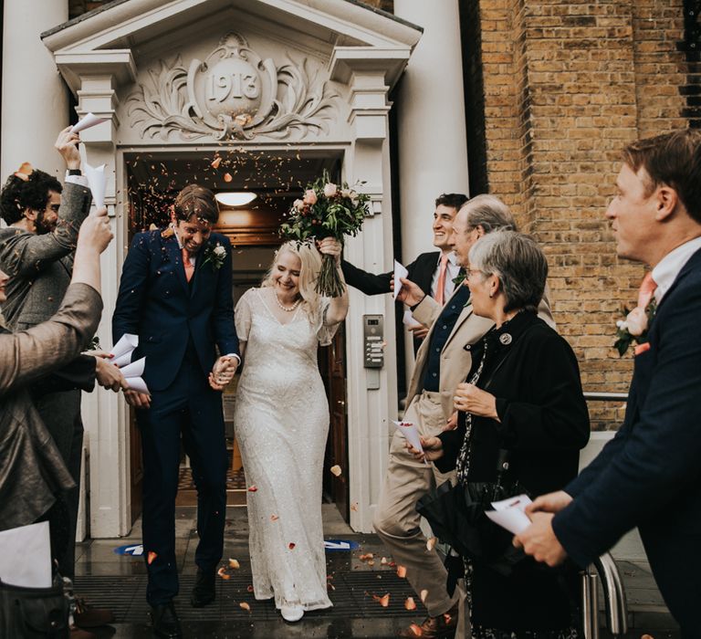 Bride & groom leave registry office with confetti being thrown