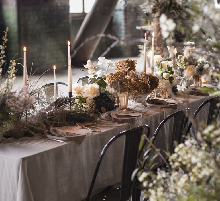 Wedding table decor with metal chairs, taper candles, natural linens and dried flowers 