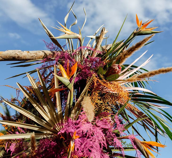 Altar floral decor at drag race wedding inspiration shoot. Created using palms, ferns and bird of paradise. Photography by Stephanie Shenton.