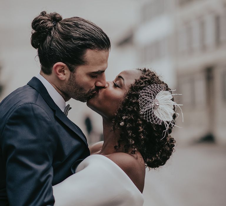 Bride & groom kiss as they stand on the street together