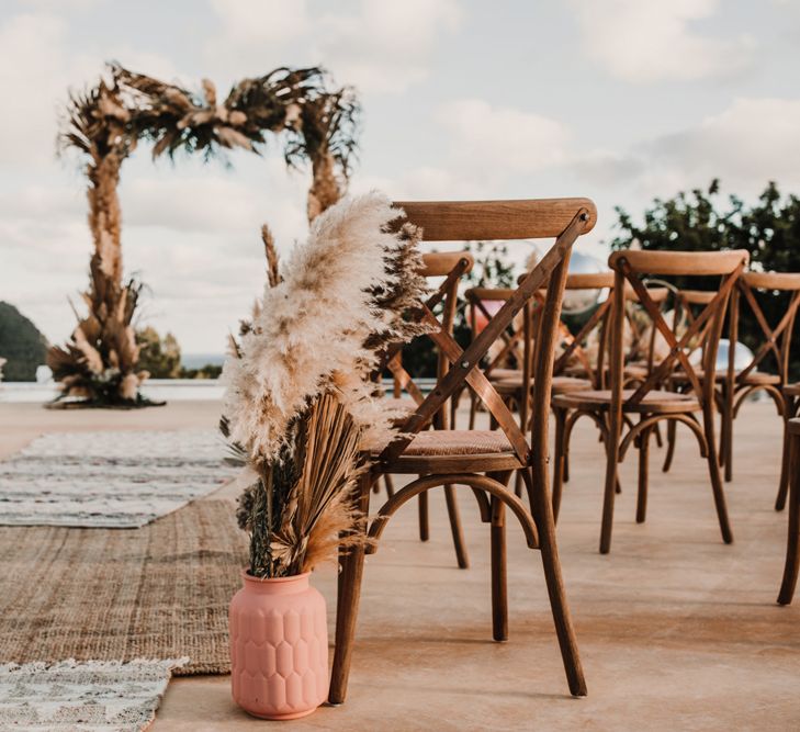 Aisle dried wedding flowers in terracotta pots with palm leaves and pampas grass 