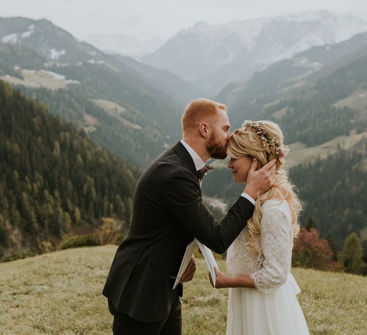 Groom kissing his brides forehead at intimate mountain elopement 