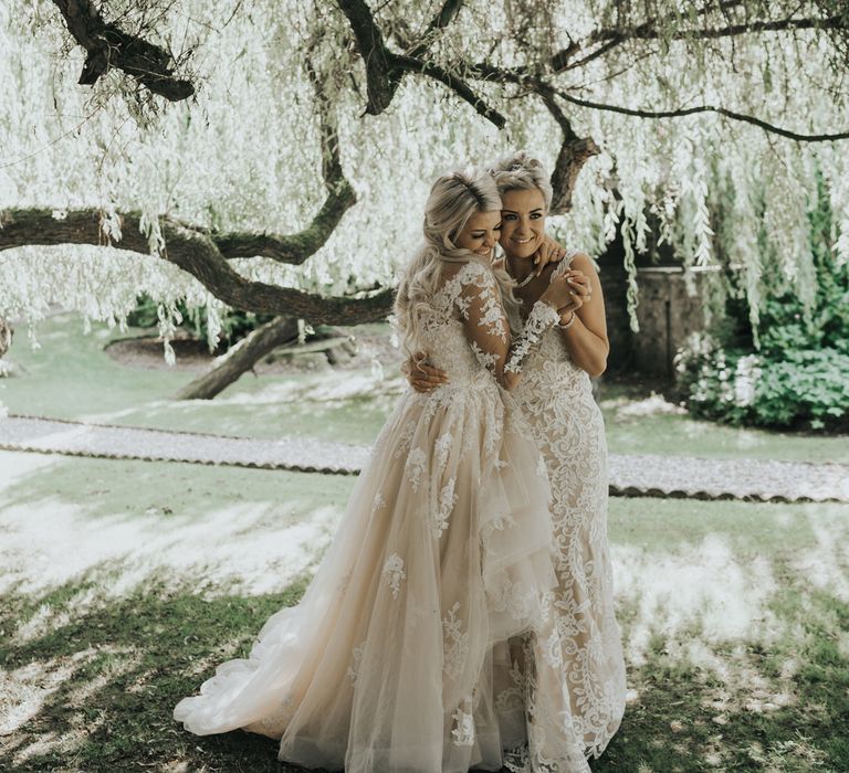 Two brides dance under the trees at Crab & Lobster fairytale wedding.