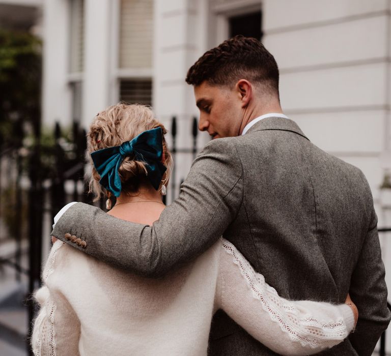 Bride in a knitted cardigan and teal velvet bow in her hair 