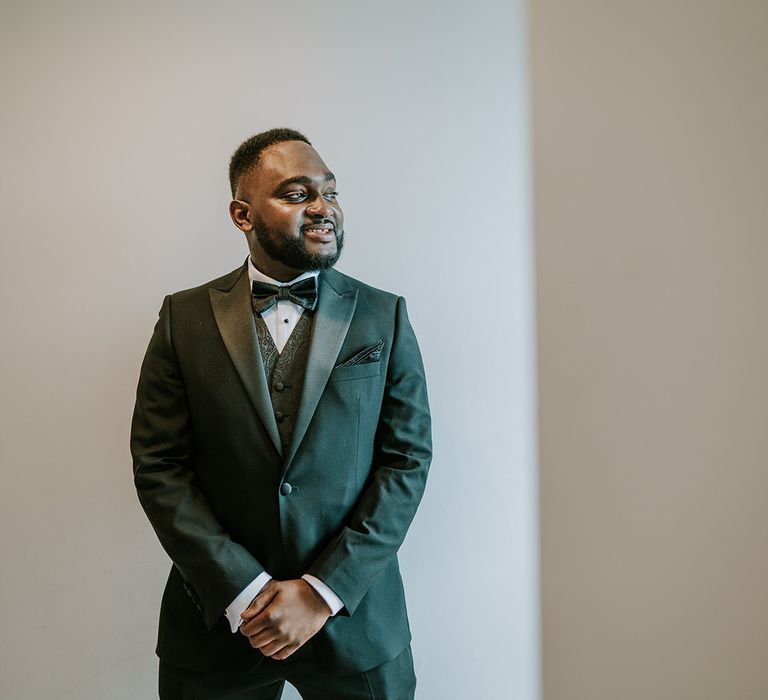 Groom wears black tie on wedding day with patterned waistcoat and matching pocket square 