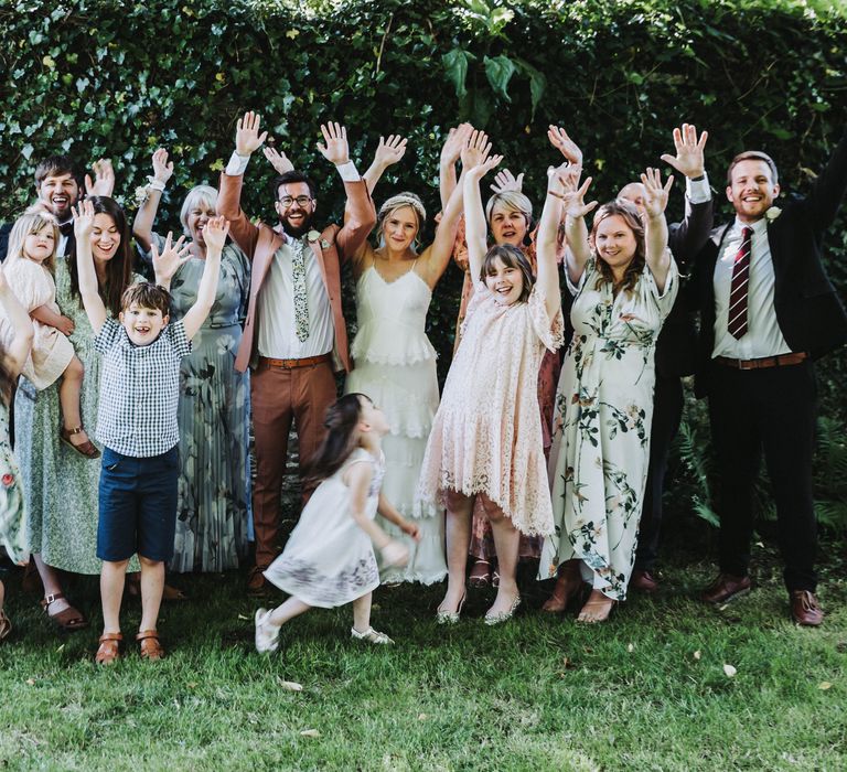 Wedding guests celebrate with one another outdoors for family pictures