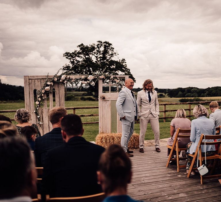 Groom waiting for his bride at rustic outdoor wedding