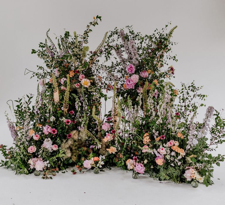 Multicoloured floral wedding installation with green foliage and pink, yellow and purple flowers for wedding at Loft Studios London