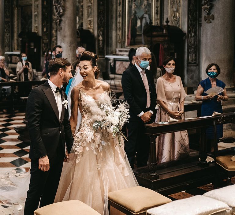 Bride & groom laugh and smile during their church wedding ceremony in Italy