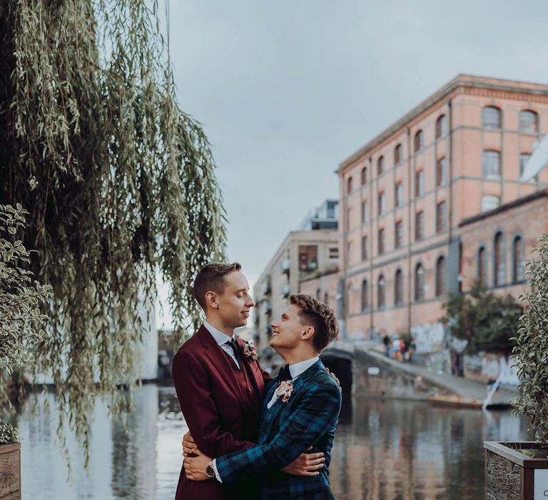 Grooms kiss on their wedding day in front of lake  | Kim Williams Weddings