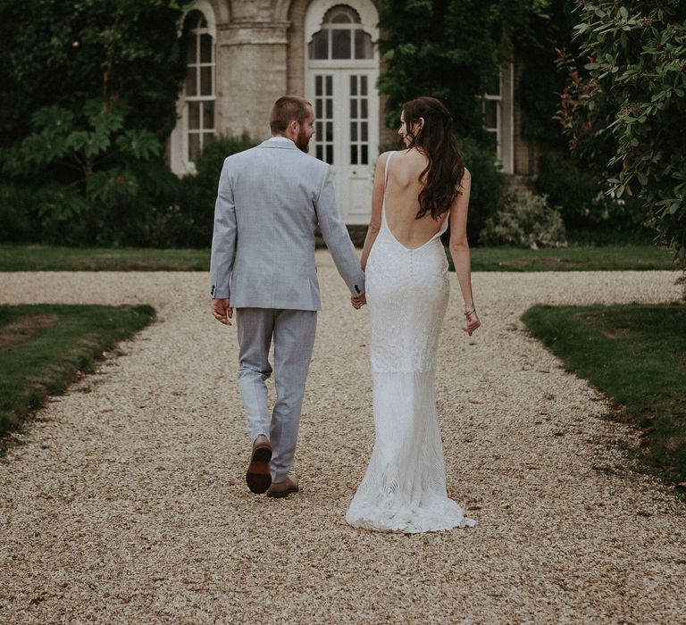 Low back wedding dress and blue wedding suit