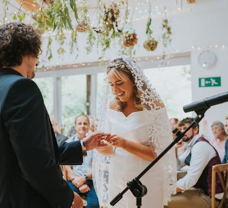 Bride & groom exchange rings during wedding ceremony 