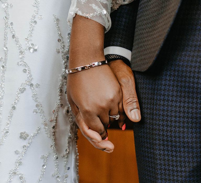 Groom holds his brides hand on the day of their wedding