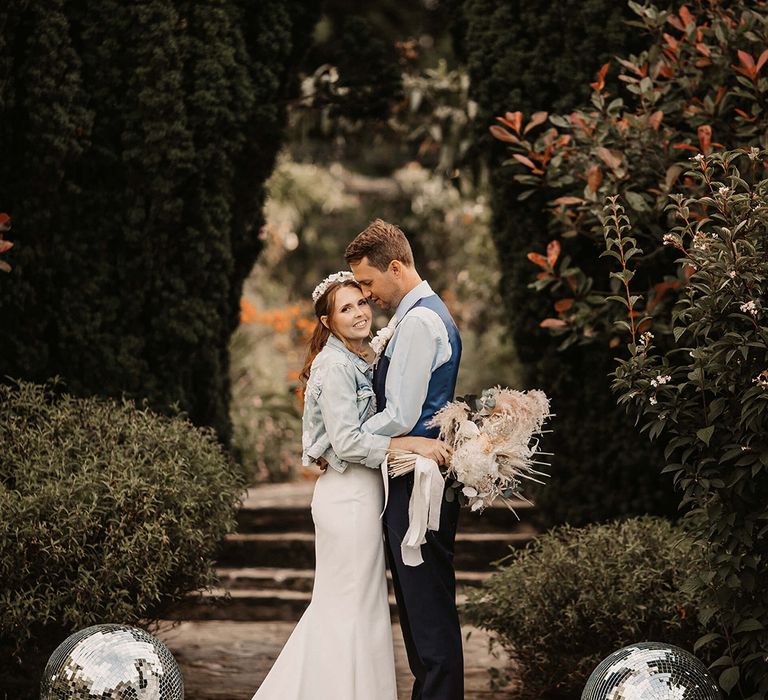 Bride & groom kiss on staircase outdoors on their wedding day