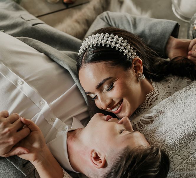 Bride & groom look lovingly at one another as they lay down the floor