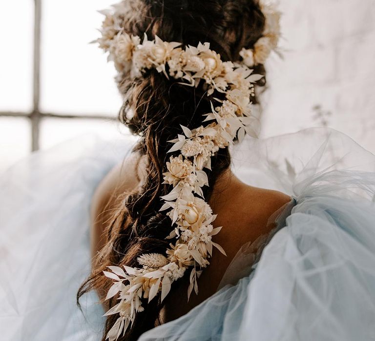 Bride with a braided plait and beige dry flower hair accessory trailing down her back 