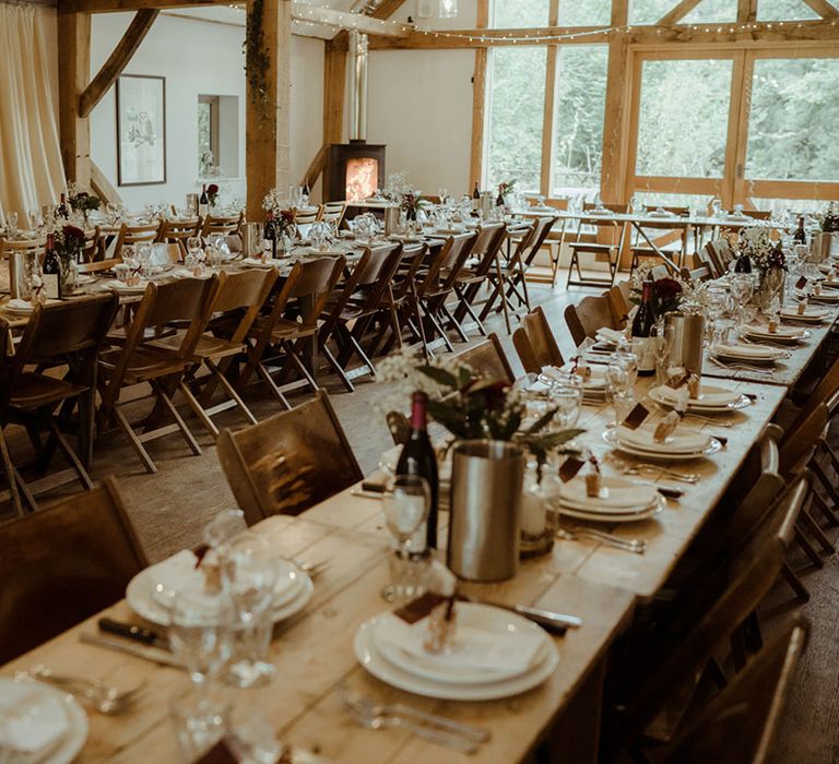 Rustic wedding setting for reception complete with wooden tables and chairs 