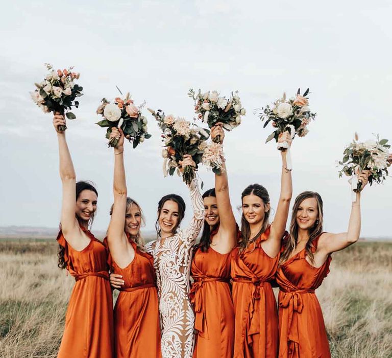 Bridesmaids in satin burnt orange bridesmaid dresses with wrap design