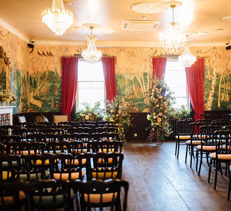 Wedding venue with forest wallpaper and hanging crystal chandeliers 