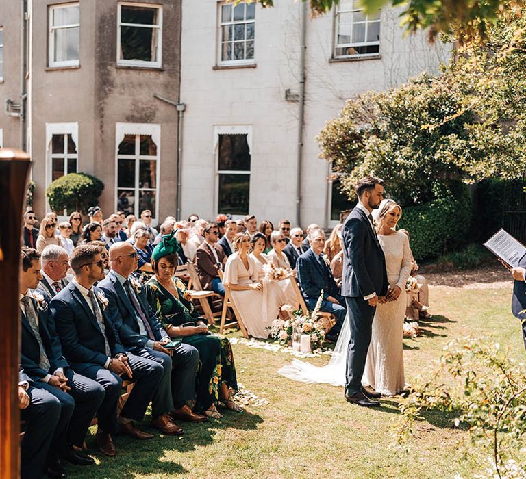 Outdoor wedding ceremony for bride and groom at Pennard House with harpist