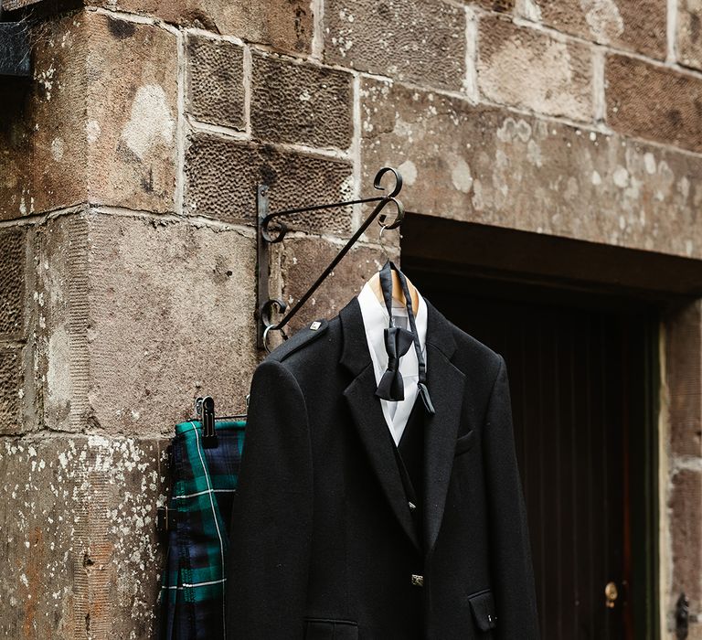 Groom's outfit hanging outside for him including kilt and black tie suit