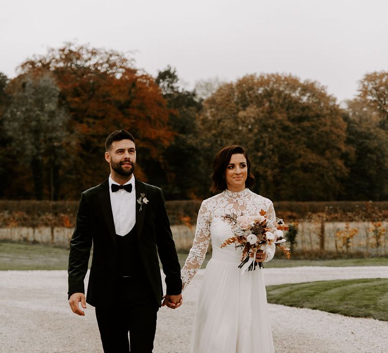 Groom in three piece velvet black tie outfit with bride in sweetheart illusion lace long sleeve wedding dress 