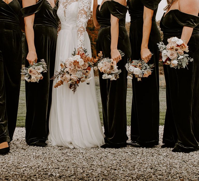 Bride and bridesmaids autumnal bouquets in their green velvet outfits and bride in lace wedding dress 